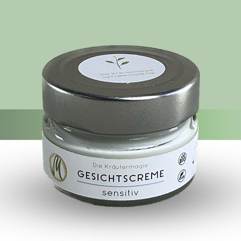Glasbehälter mit silbernem Deckel. Aufschrift: GESICHTSCREME sensitiv. Logo und Bio-Siegel. Produktname: Die Kräutermagie.