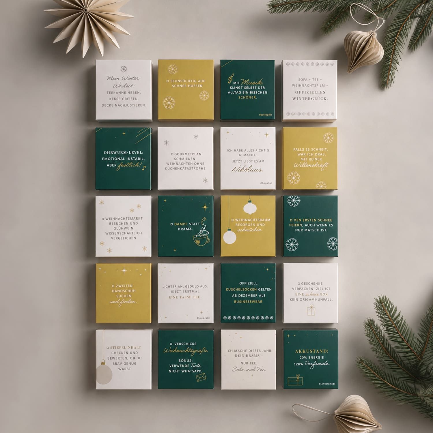 24 kleine quadratische Schachteln mit Tee, angeordnet in einem Raster, weihnachtliche Dekoration.