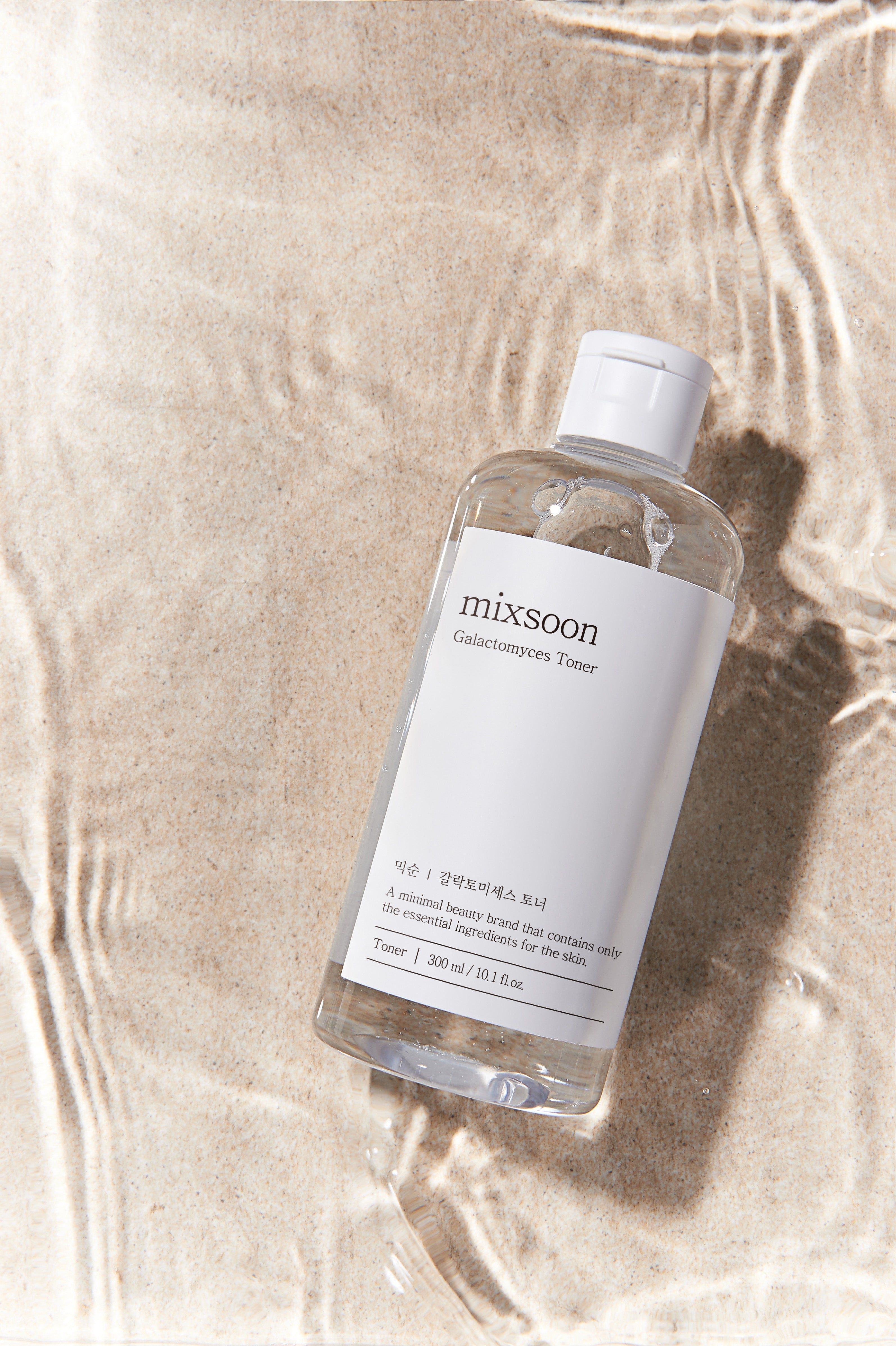 Klare Flasche mit weißem Etikett im Wasser. Aufschrift: mixsoon Galactomyces Toner. Untertitel und Volumenangabe.