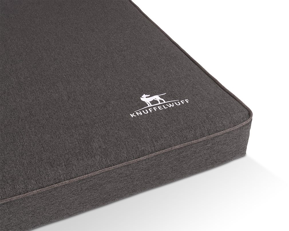 Detailansicht der orthopädischen Hundematte Nantucket. Graues Material, weißes Logo. Helle Zierband.
