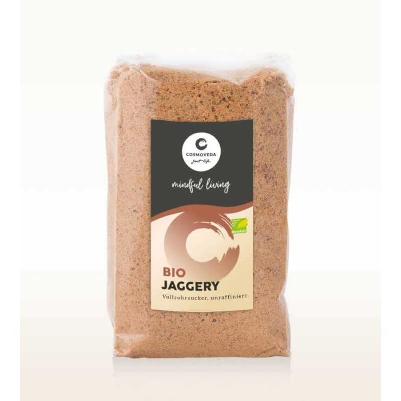 Verpackung mit BIO Jaggery Vollrohrzucker. Schwarzes Etikett mit Logo, Schriftzug und Bio-Siegel. Brauner Zucker in transparenter Folie.