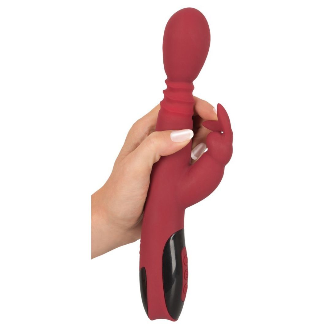 Roter Vibrator in Hand gehalten. Schwarzes Bedienfeld mit Knöpfen. Kaninchenform und geriffelte Textur.