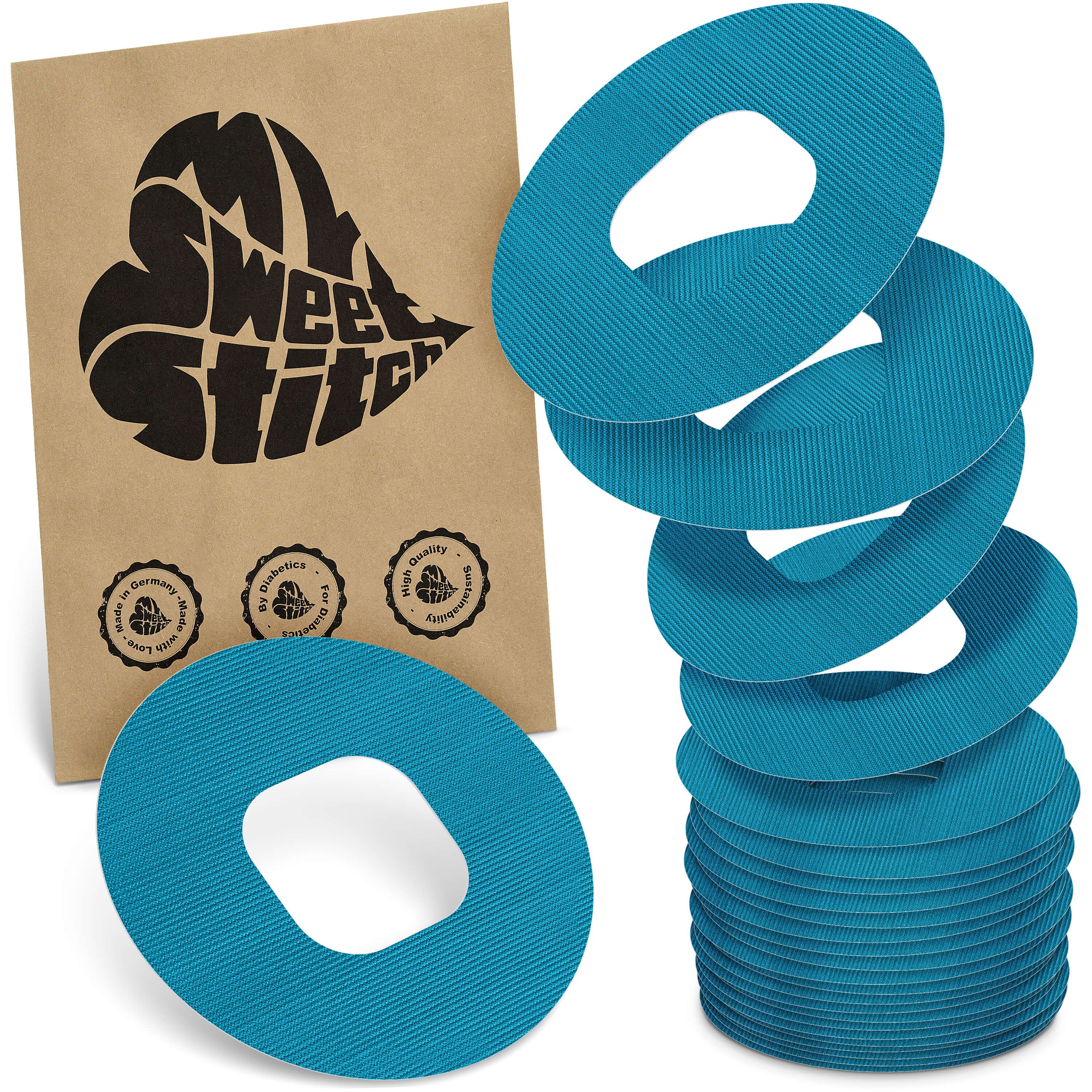 Türkisfarbene, ringförmige Pflaster mit Loch in der Mitte. Auf brauner Verpackung steht "My Sweet Stitch".