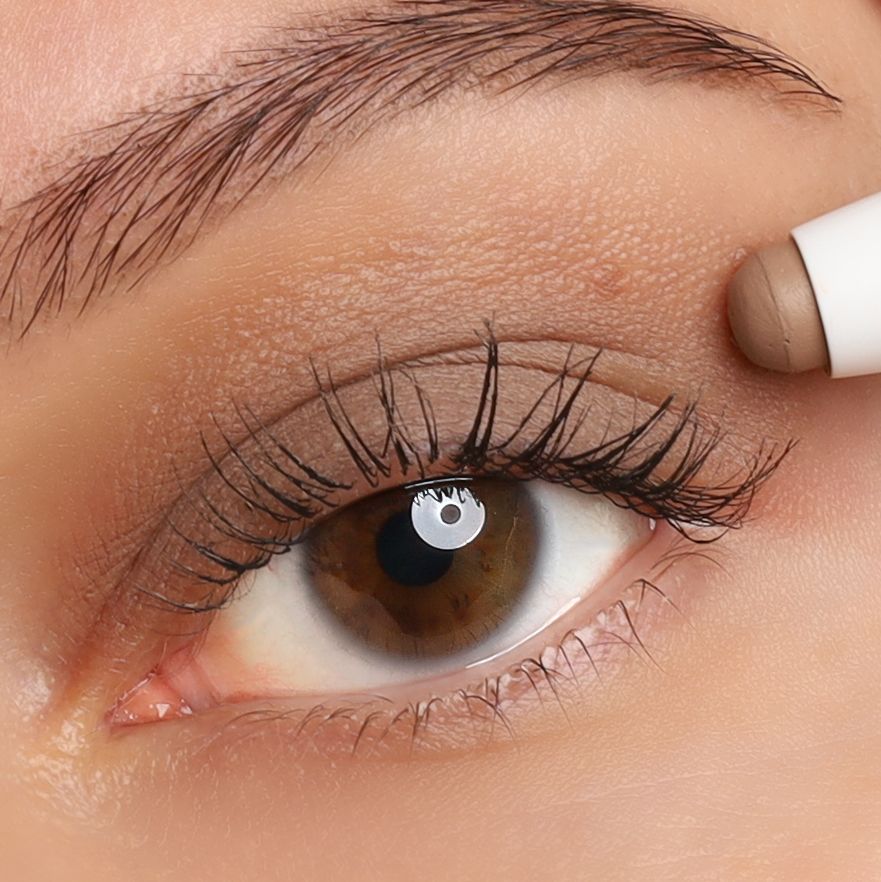 Auge mit aufgetragenem Lidschatten. Braunes Auge mit Lidschatten. Lidschattenstift wird verwendet.