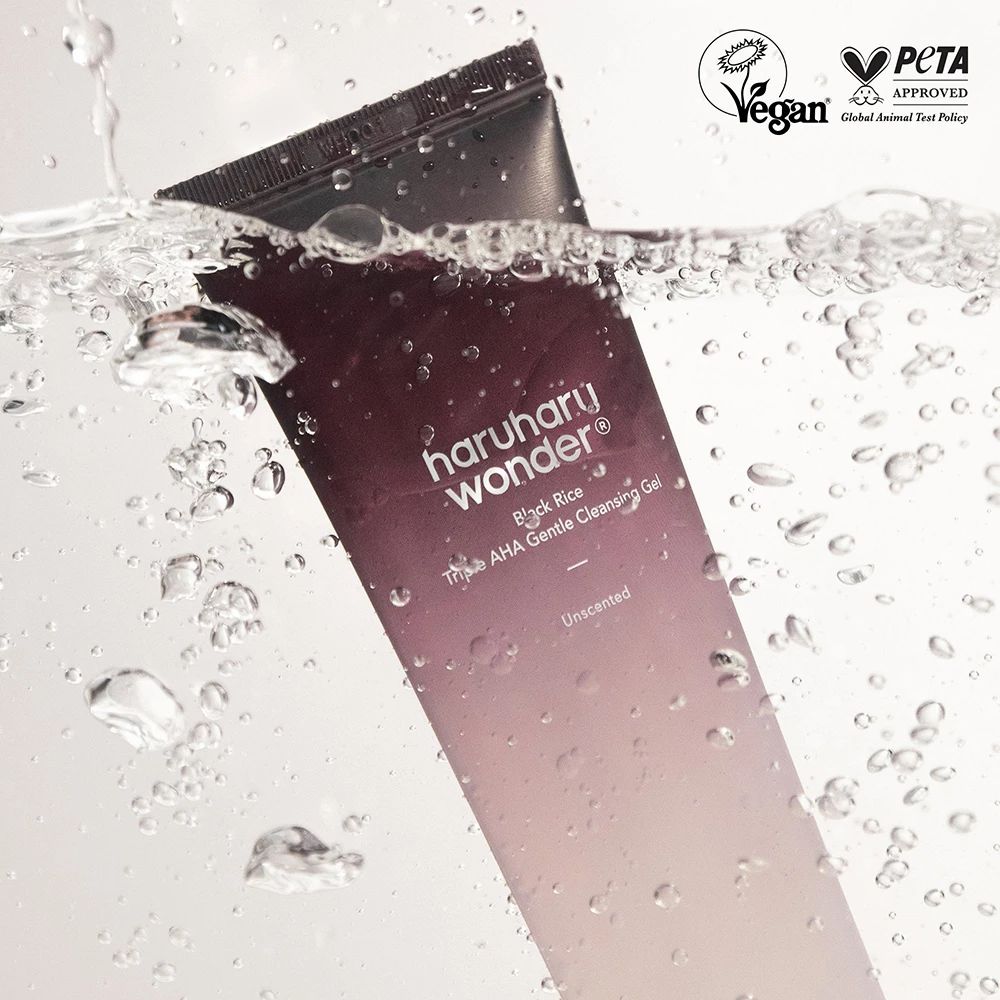 Tube im Wasser. Aufschrift: Haruharu Wonder Black Rice Triple AHA Gentle Cleansing Gel. Vegan- und PETA-Siegel. Wasserblasen.