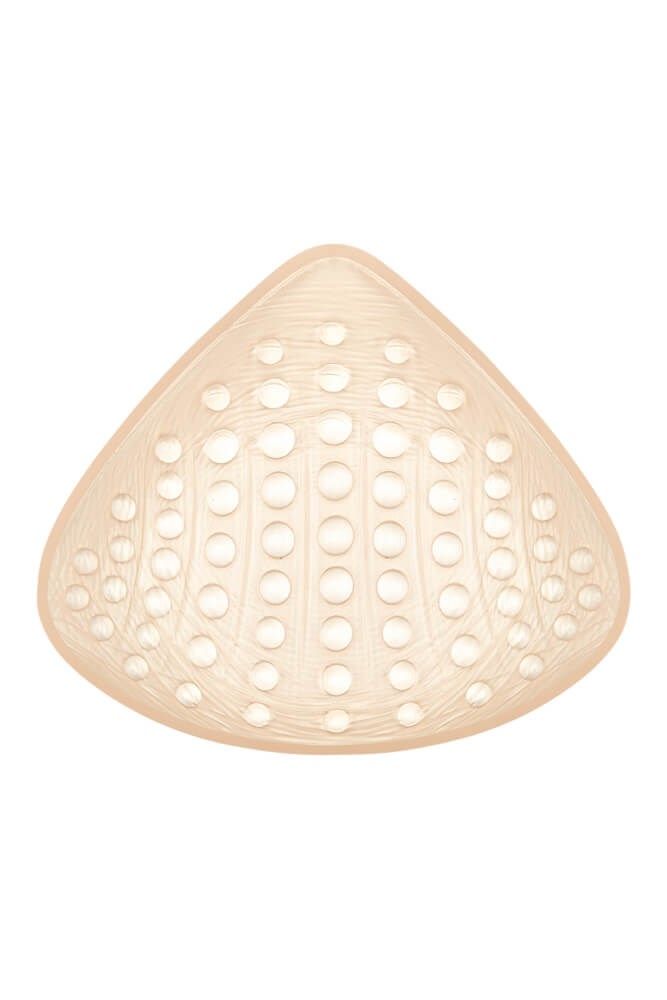 Brustprothese in Dreiecksform, hautfarben. Mit Löchern auf der Oberfläche. Strukturierte Oberfläche.
