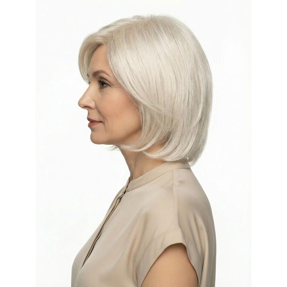 Perücke STOCKHOLM, hellblond, mit Seitenscheitel. Frau mit Perücke, helles Oberteil. Seitenansicht.