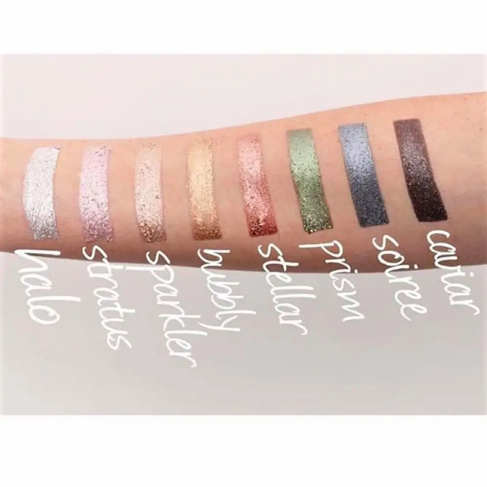 Arm mit 9 Lidschatten-Swatches. Farben: Halo, Stratus, Sparkler, Bubbly, Stellar, Prism, Soiree, Caviar.