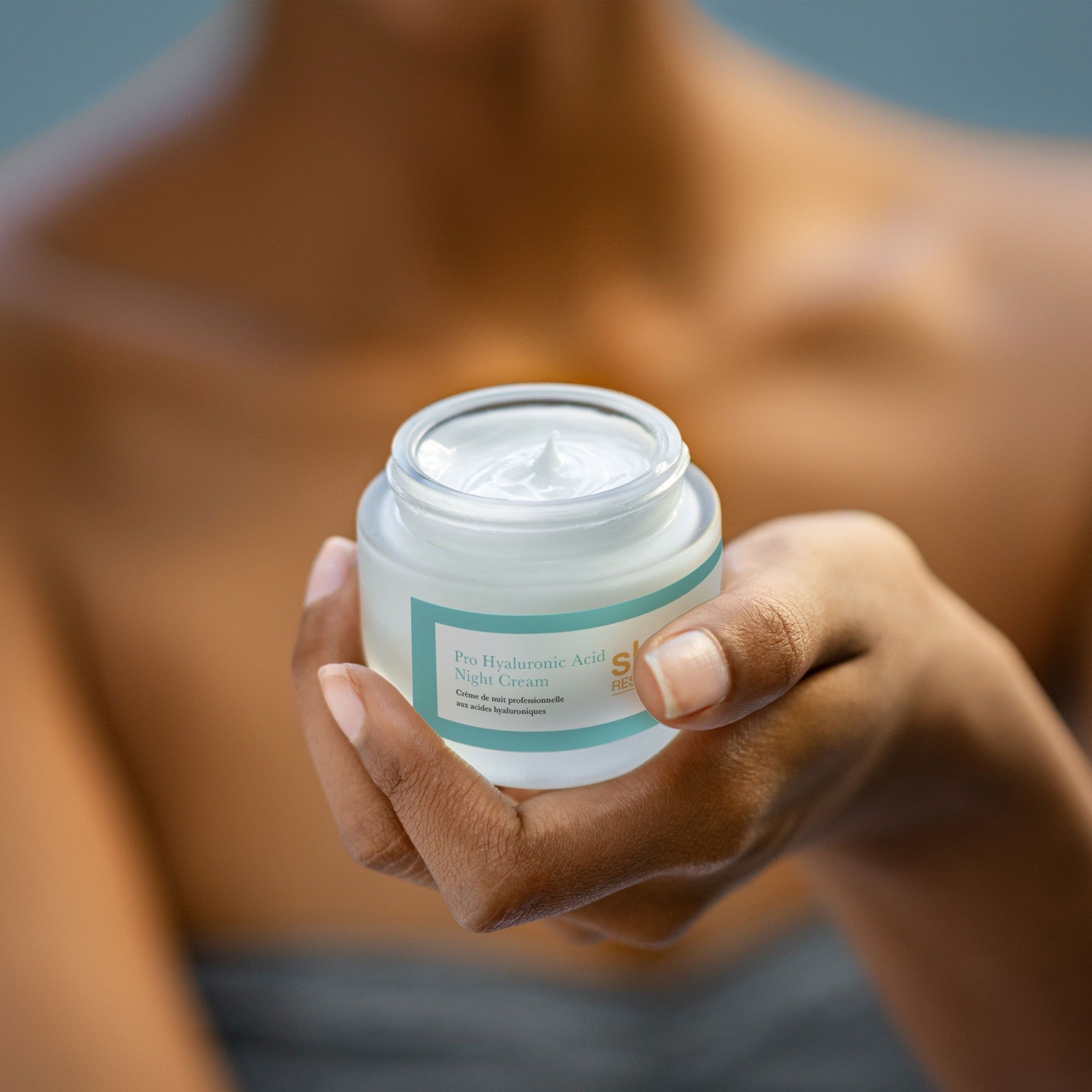 Person hält Creme-Glas. Aufschrift: Pro Hyaluronsäure Nachtcreme. Marke: skin research. Creme sichtbar.