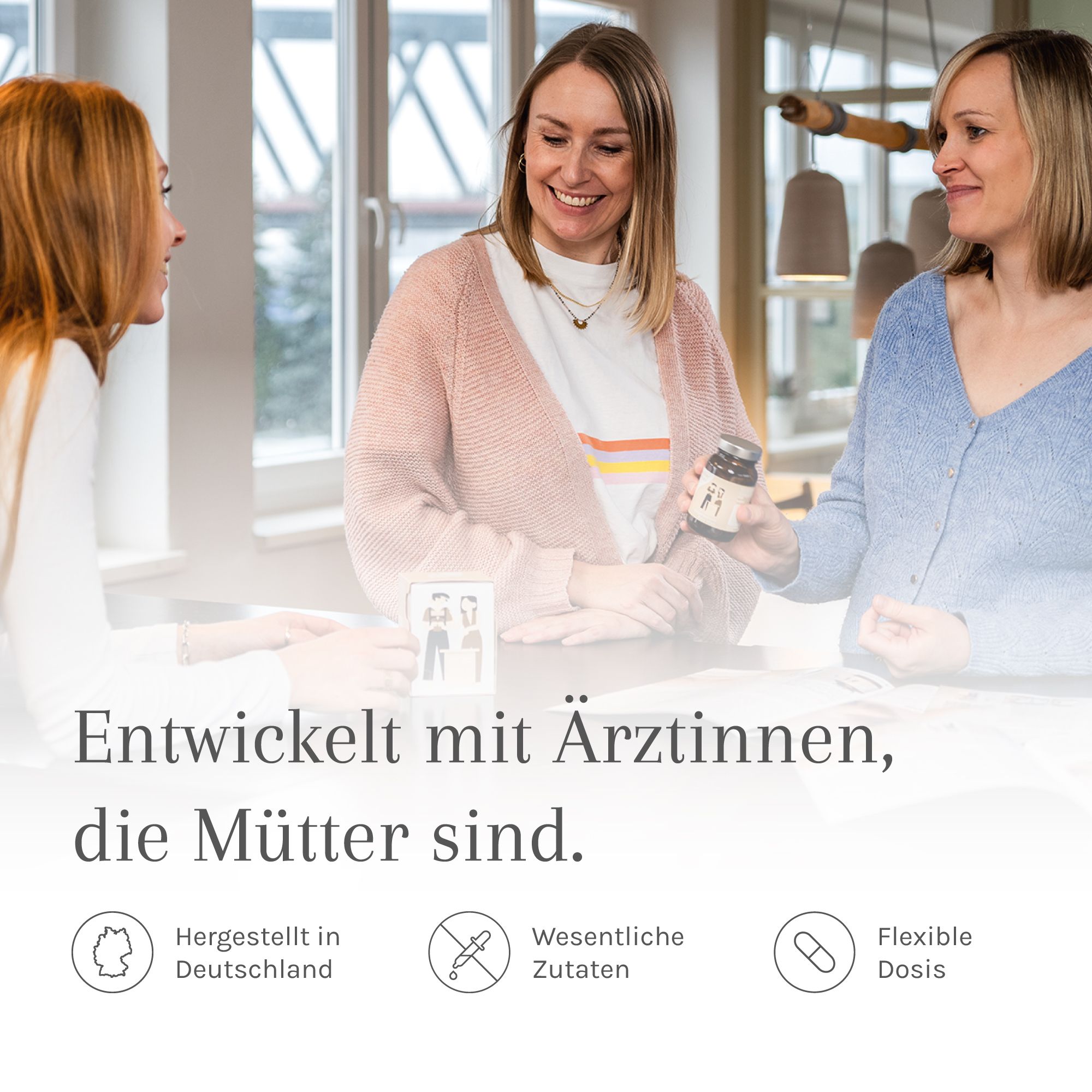 Drei Frauen sitzen zusammen. Eine hält eine Flasche. Text: Entwickelt mit Ärztinnen, die Mütter sind.