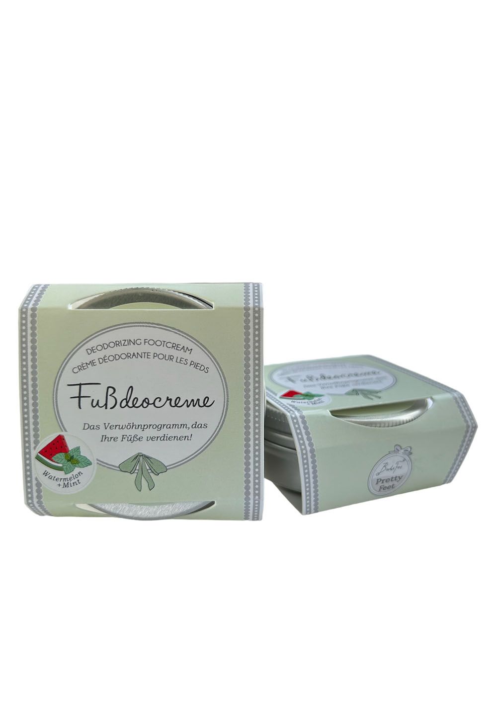 Zwei hellgrüne Kartons mit Fußdeocreme. Aufschrift: Fußdeocreme, Wassermelone & Minze. Mit Griffen.