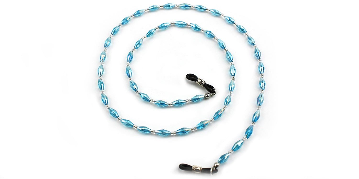 Brillenkette mit blauen, ovalen Perlen und silberfarbenen Verbindungen. Enden mit schwarzen Gummischlaufen.