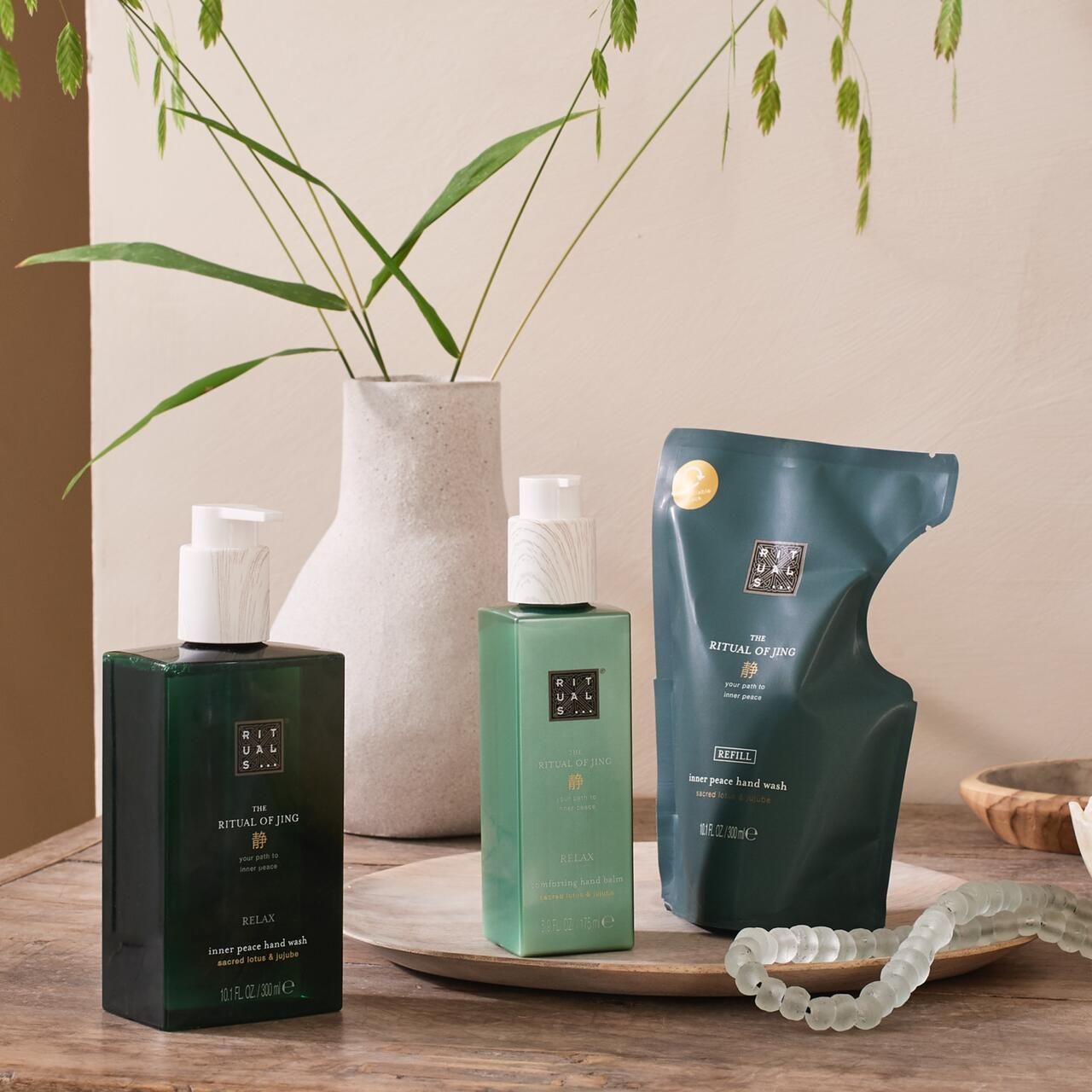 Handwaschmittel, Handbalsam und Nachfüllpackung. Grüne Flaschen mit weißen Pumpen. Aufschrift: The Ritual of Jing.