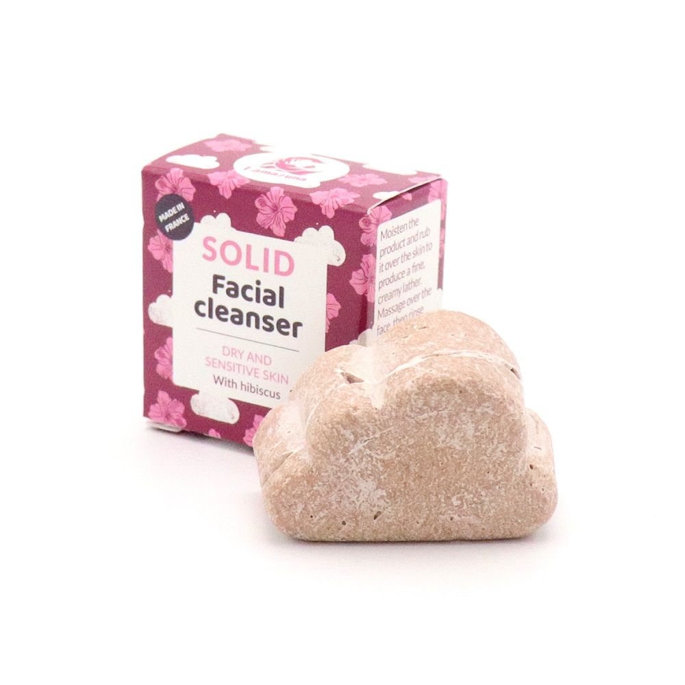 Festes Gesichtsreinigungsmittel in Wolkenform neben Verpackung. Verpackung mit floralem Muster und Text: "Solid Facial Cleanser".