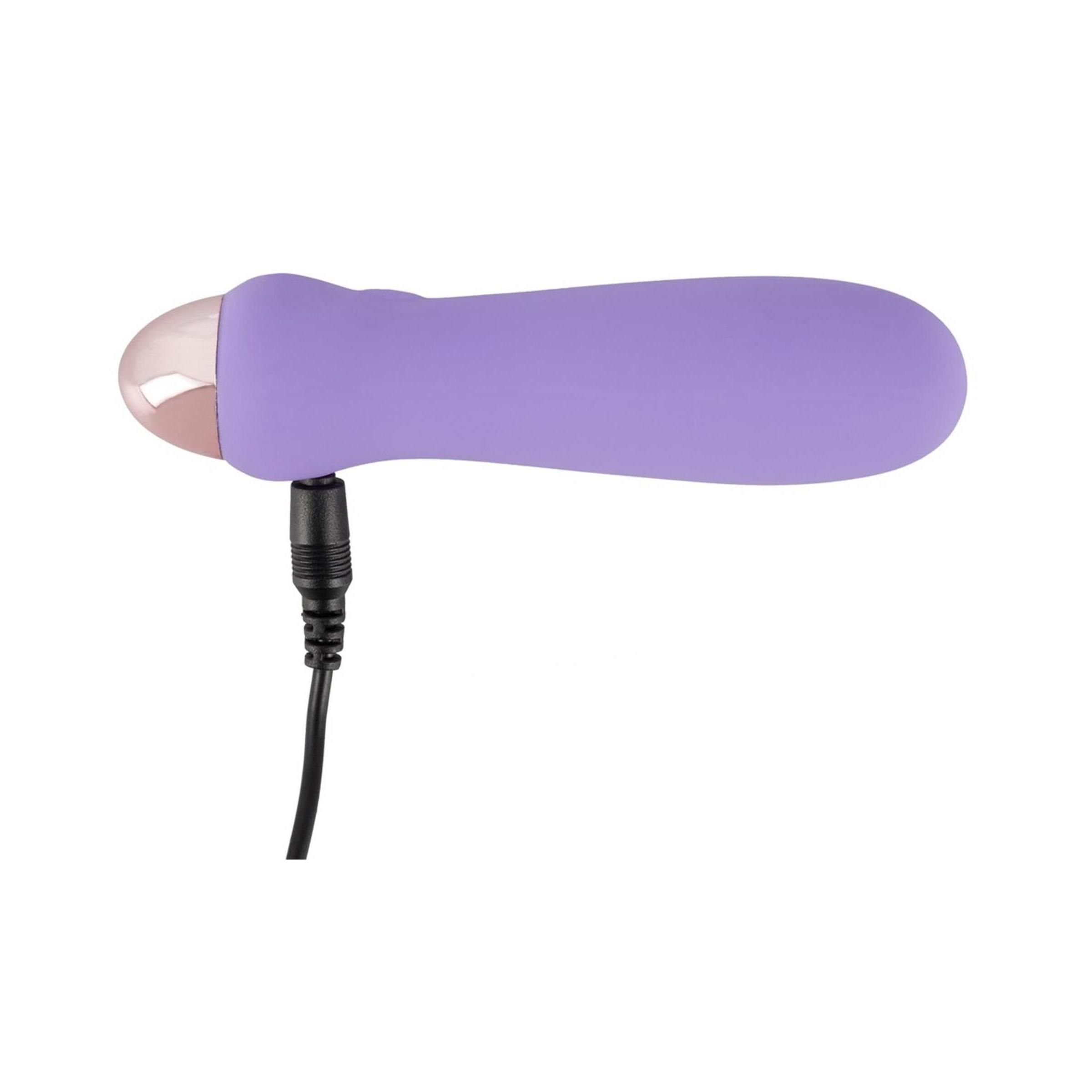Lila Vibrator mit angeschlossenem Ladekabel. Rosafarbener Kopf. Schwarzes Kabel.