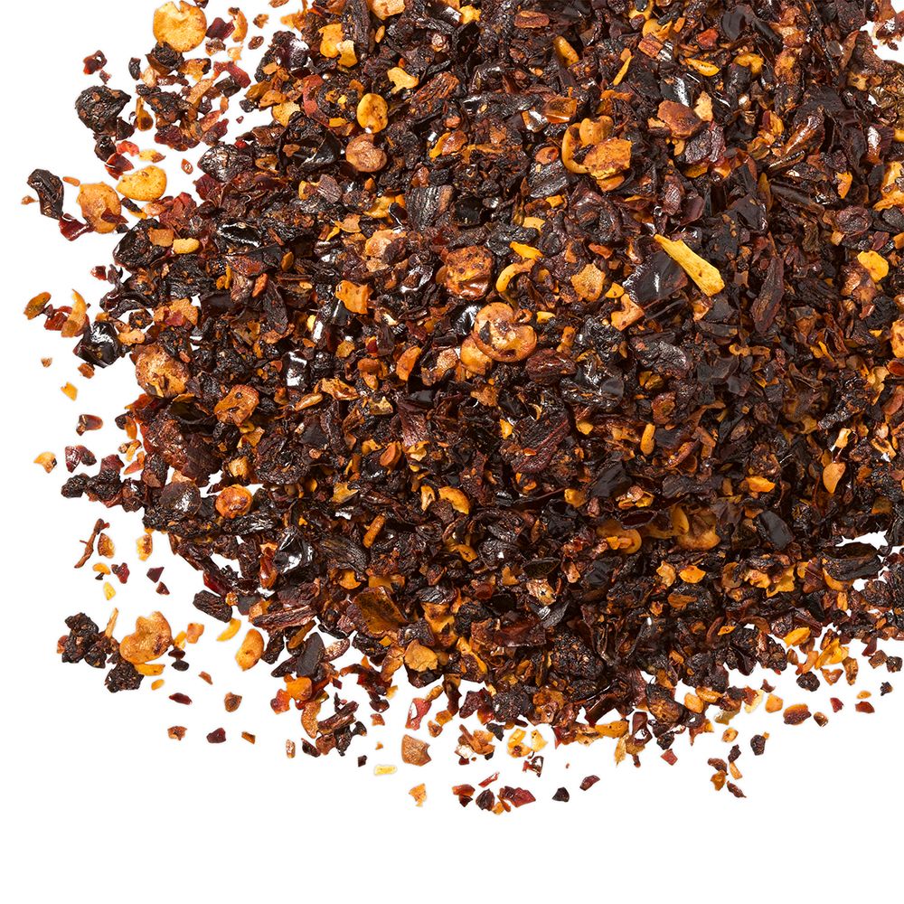 Haufen getrockneter Chiliflocken. Verschiedene Farben und Größen.