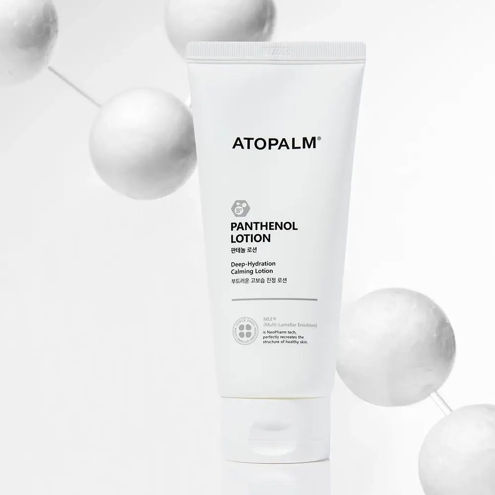 Weiße Tube ATOPALM Panthenol Lotion. Text: Deep Hydration Calming Lotion. Hintergrund: weiße Kugeln.