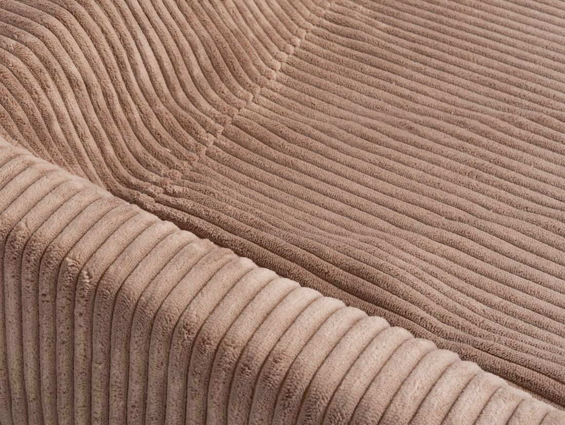 Nahaufnahme der Oberfläche eines orthopädischen Hundebetts. Beige, Cord-Optik. Nähte sichtbar. Texturdetails.