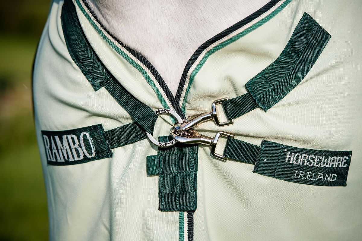 Detailansicht der Ekzemerdecke. Aufnäher mit "RAMBO" und "HORSEWARE IRELAND". Dunkelgrüne Gurte und silberne Schnallen.