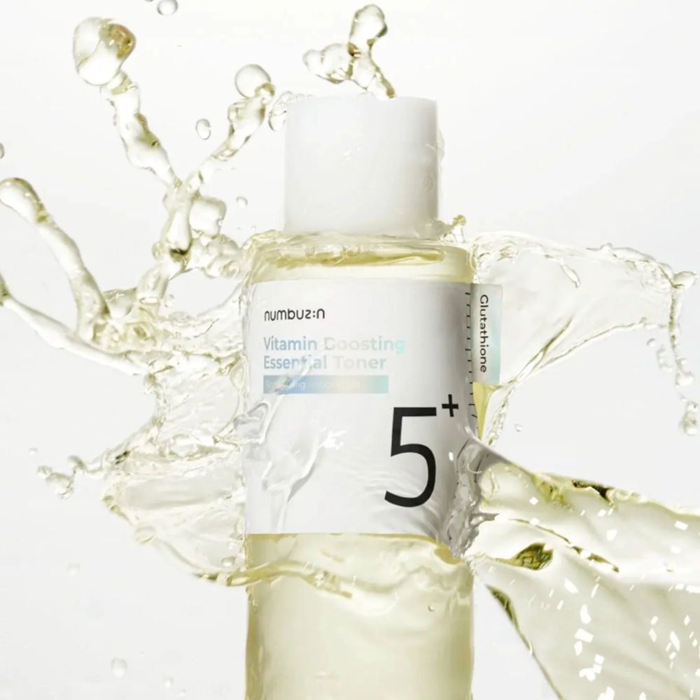 Flüssigkeitsspritzer um eine zylindrische Flasche mit weißem Deckel. Aufkleber mit Text: Vitamin Boosting Essential Toner, 5+.