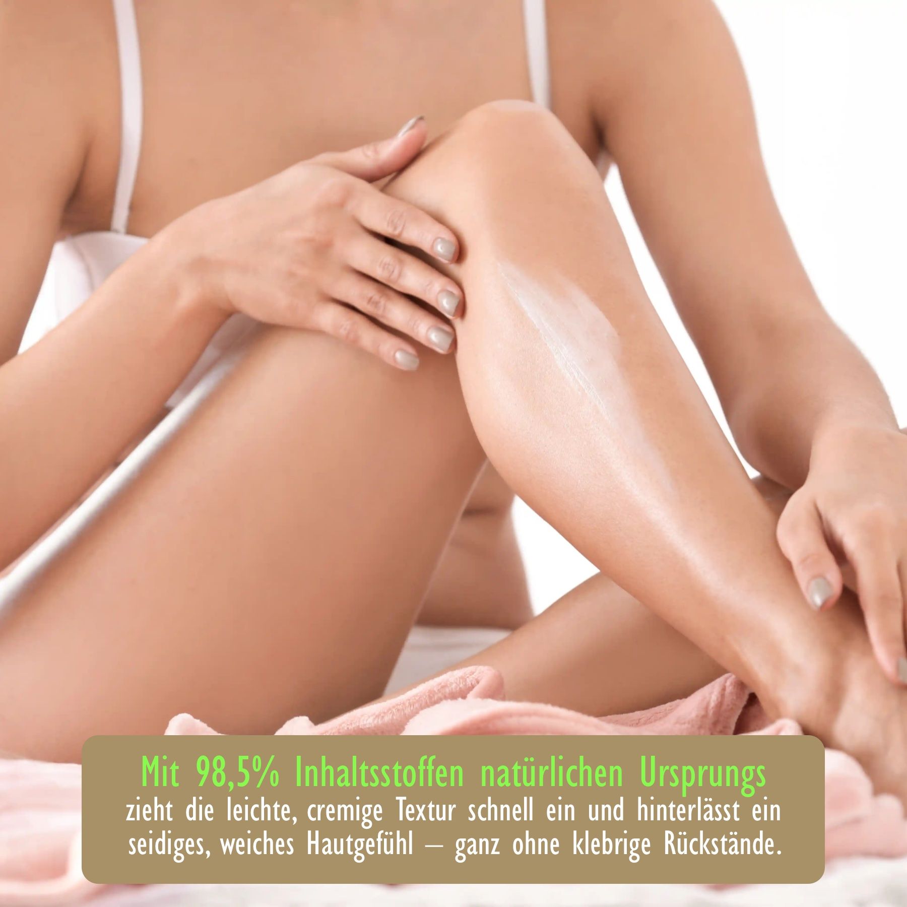 Eine Person trägt Body Milk auf ihr Bein auf. Auf dem Bein ist die Body Milk sichtbar. Text: 98,5% Inhaltsstoffe natürlichen Ursprungs.