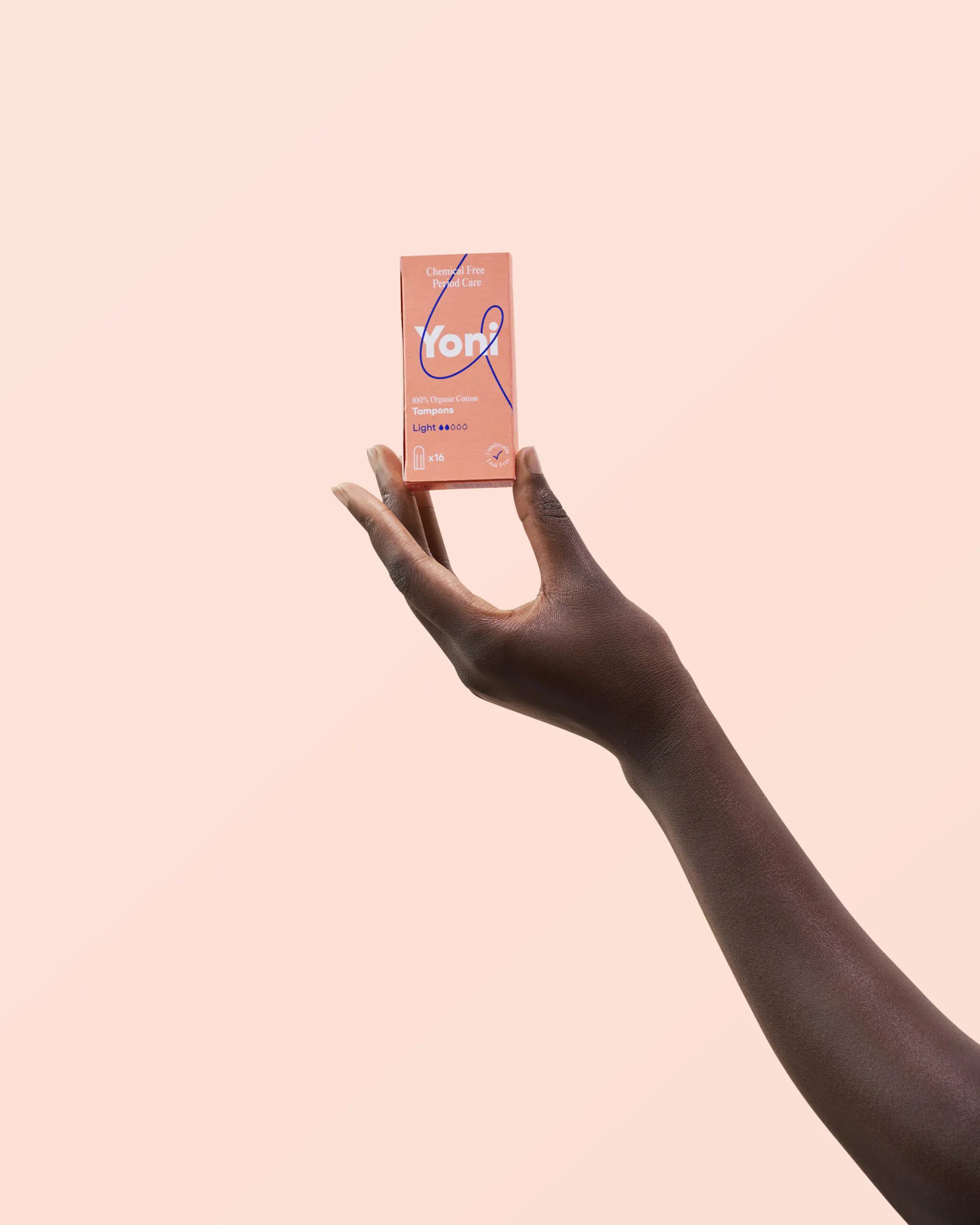 Eine Hand hält eine rosa Schachtel mit dem Yoni-Logo. Auf der Schachtel steht "Light" und "Mini Tampons".