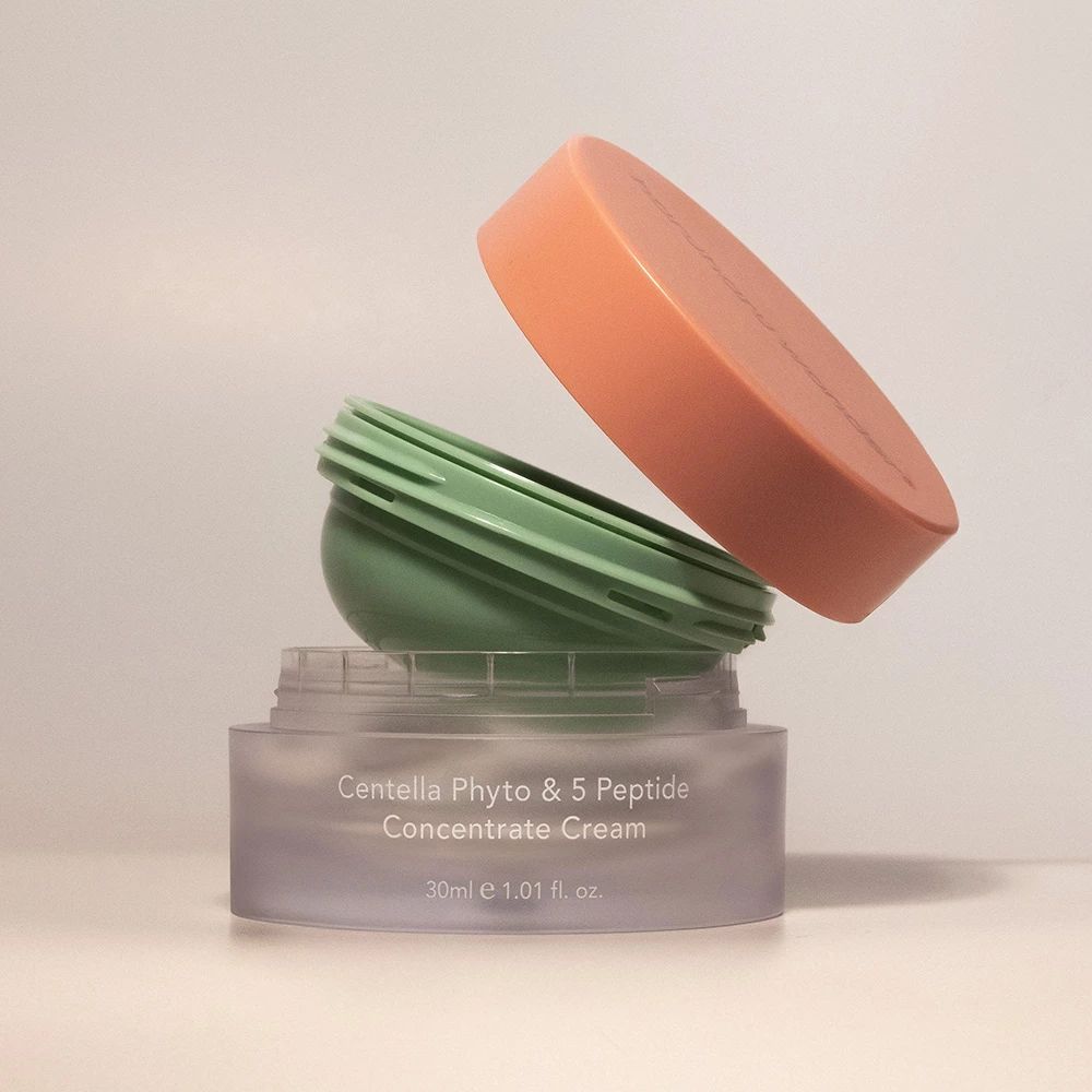 Geöffnete Creme-Dose mit Deckel. Dose und Deckel sind in verschiedenen Farben gehalten.