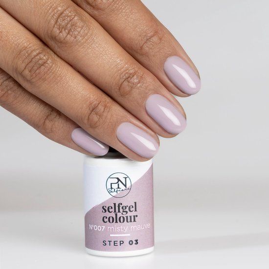 Hand mit lackierten Nägeln in Misty Mauve. Darunter eine Flasche mit Produktinformationen.