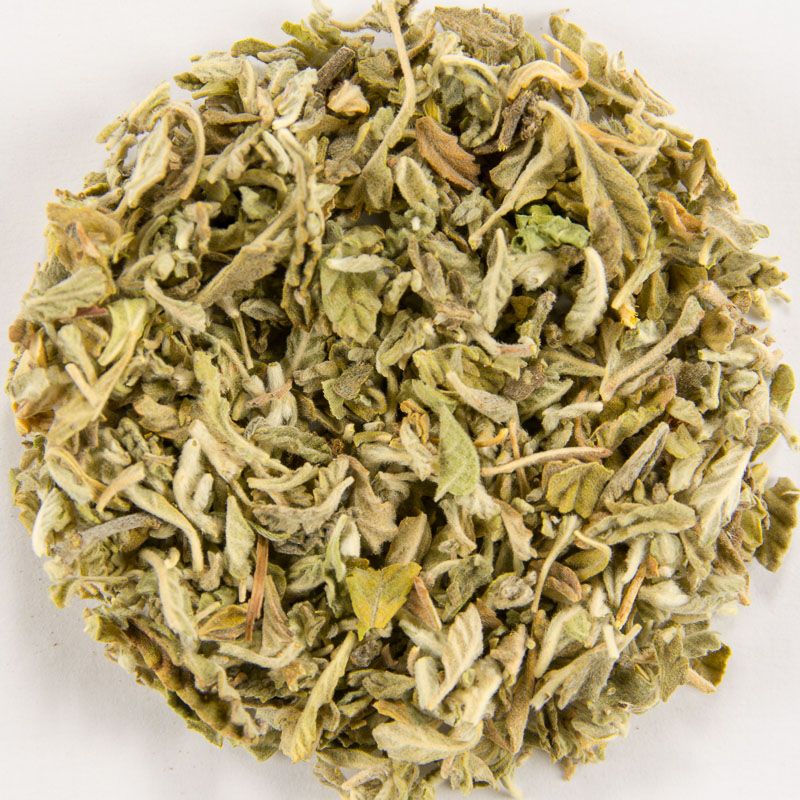 Nahaufnahme getrockneter, zerkleinerter Kräuter. Grünliche Farbe, detaillierte Blätter und Stiele.