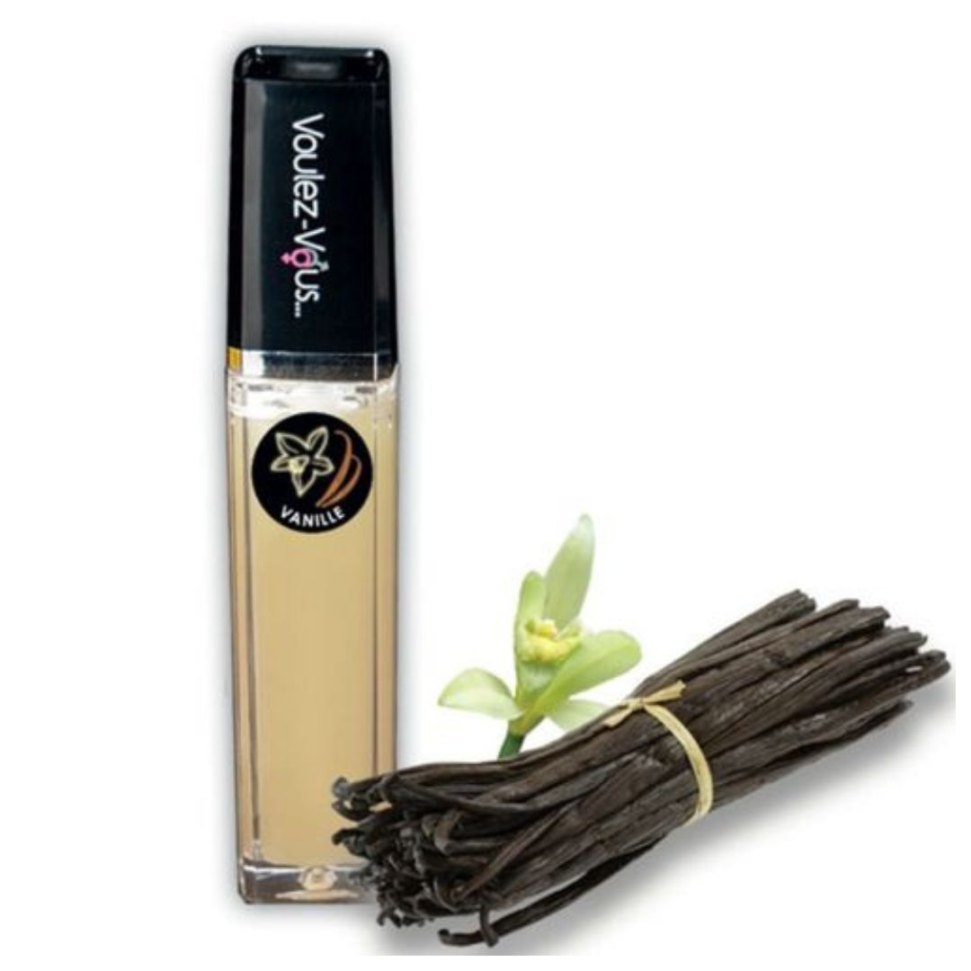 Lipgloss-Flakon mit schwarzem Deckel. Aufschrift: Voulez-Vous. Etikett mit Vanille-Logo. Daneben: Vanilleschoten und Blüte.