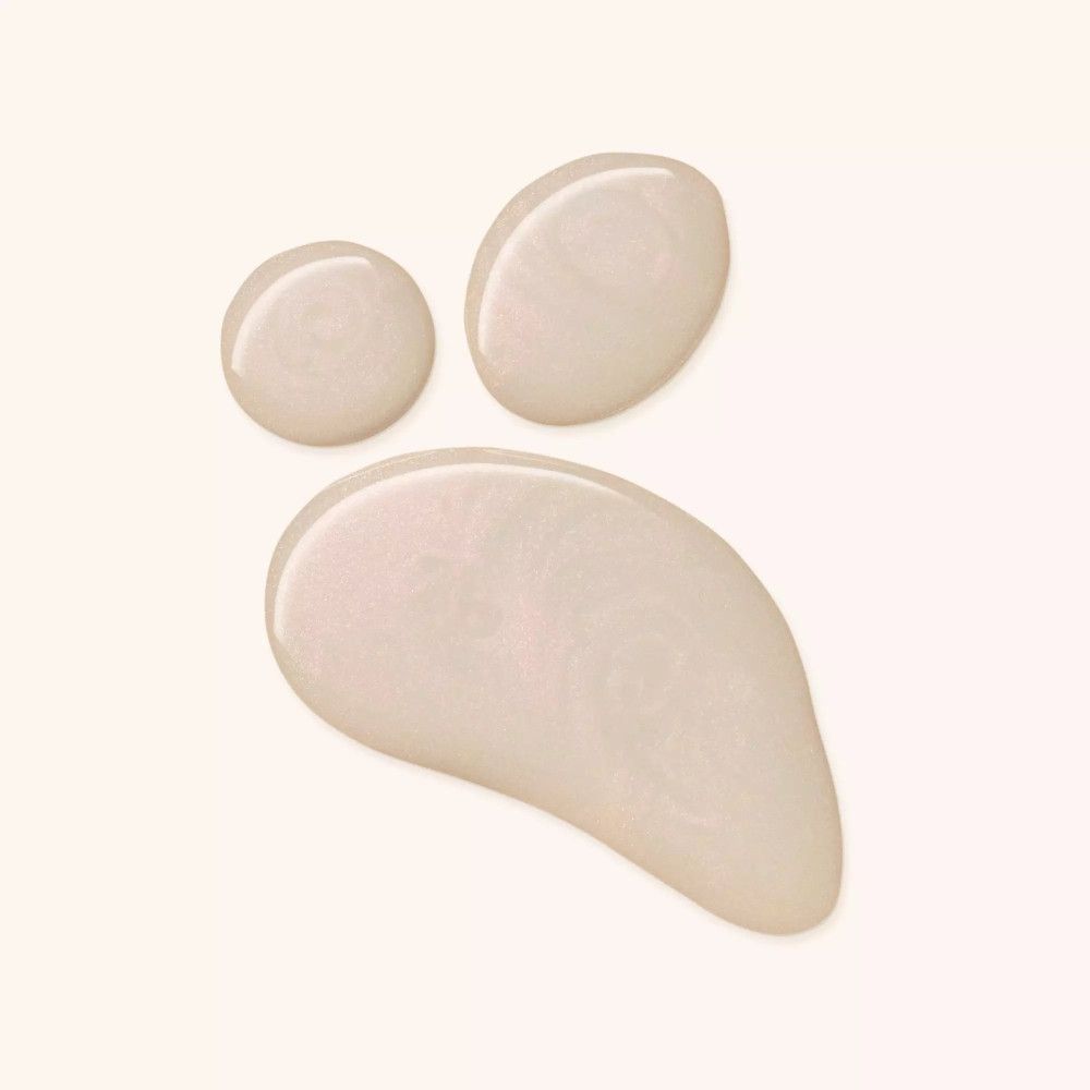 Drei Tropfen Catrice Skin Glaze Serum-Primer auf hellem Hintergrund.