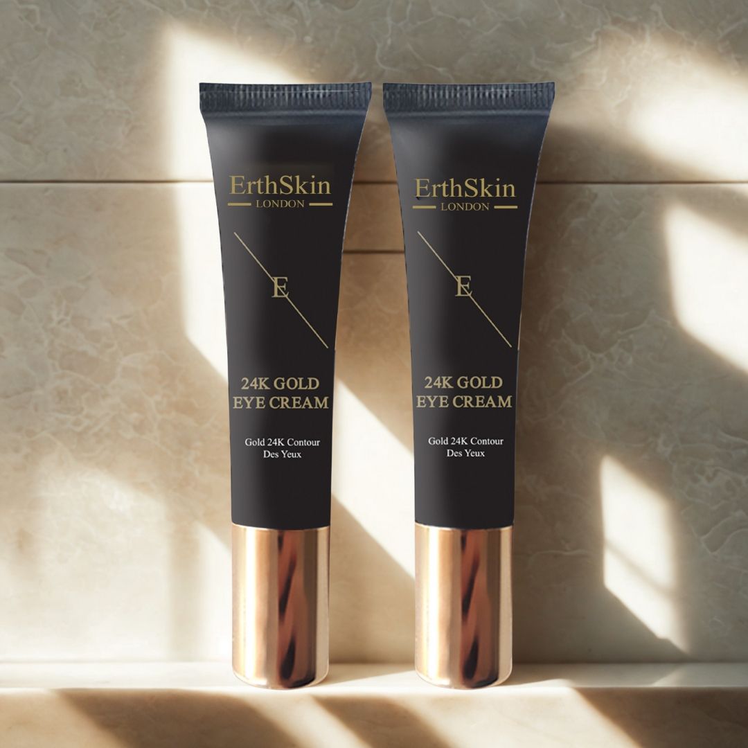 Zwei Tuben Augencreme. Schwarze Tuben mit goldfarbenen Akzenten. Aufschrift: ErthSkin London, 24K Gold Eye Cream. Auf Fliesen platziert.