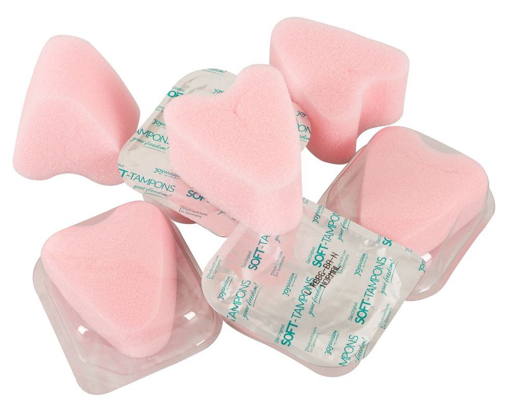 Rosa Tampons, herzförmig, ohne Faden. Einzeln verpackt in Folie. Mehrere Tampons liegen daneben.