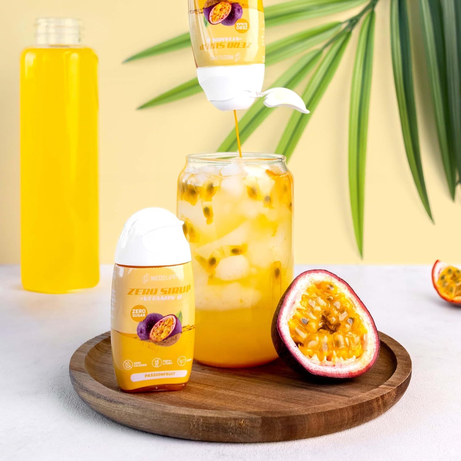 Sirup wird in ein Glas gegossen. Auf dem Tisch stehen eine Flasche, ein Glas mit Eiswürfeln und eine Passionsfrucht. Auf der Flasche steht Zero Sirup.