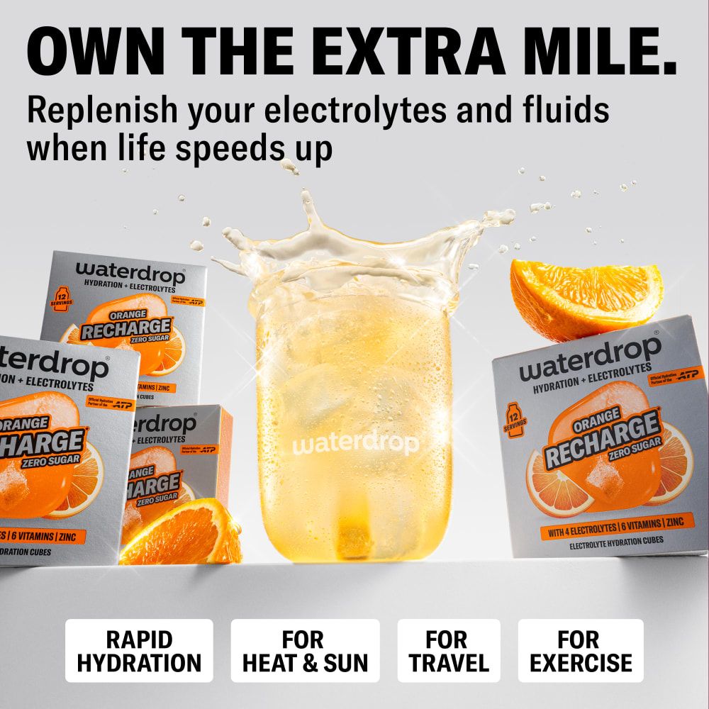 Glas mit erfrischendem orangefarbenem Getränk, umgeben von waterdrop® Orange Recharge Päckchen und Orangenscheiben.