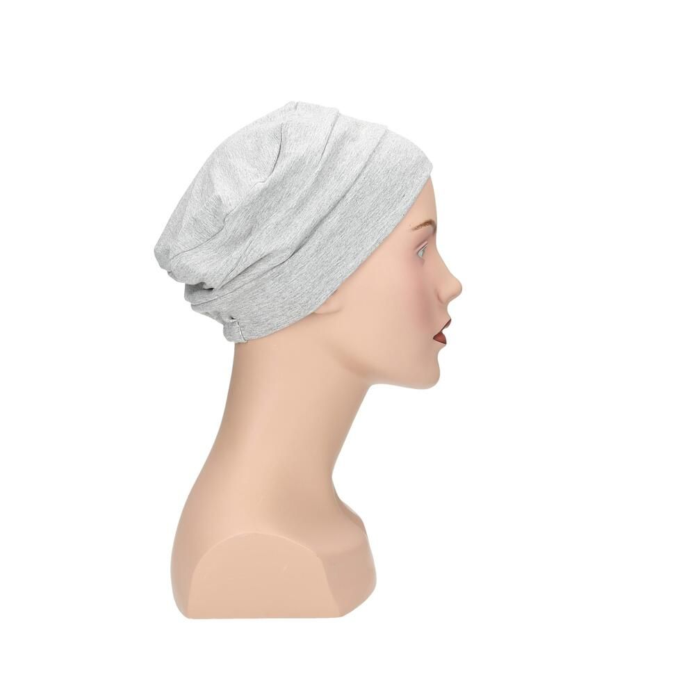 Hellgrauer Turban auf einer Schaufensterpuppe. Seitenansicht. Stoffhaube mit geraffter Struktur.