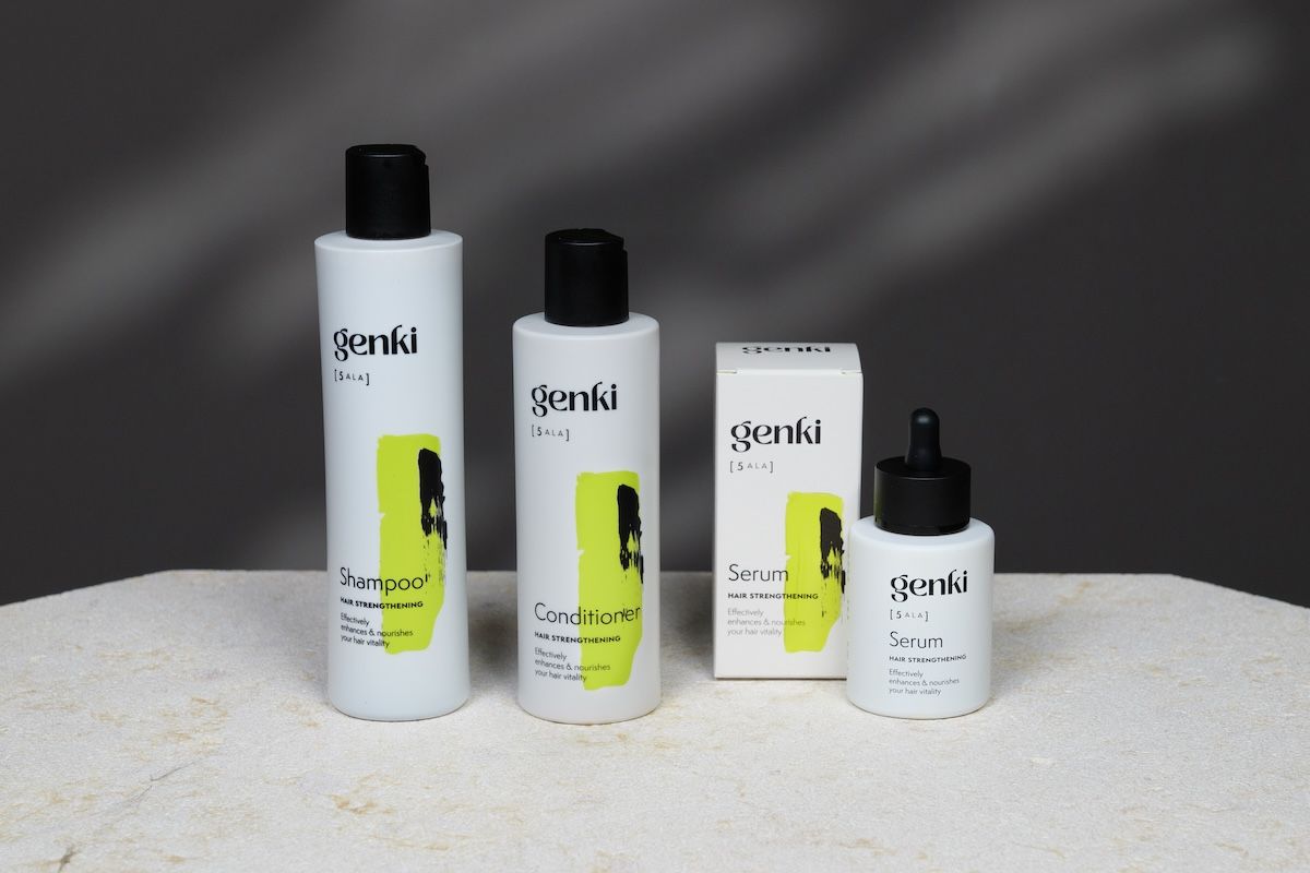 Genki-Haarpflegeset: Shampoo, Conditioner, Serum und Schachtel. Weiße Flaschen mit schwarzem Deckel und gelbem Akzent.