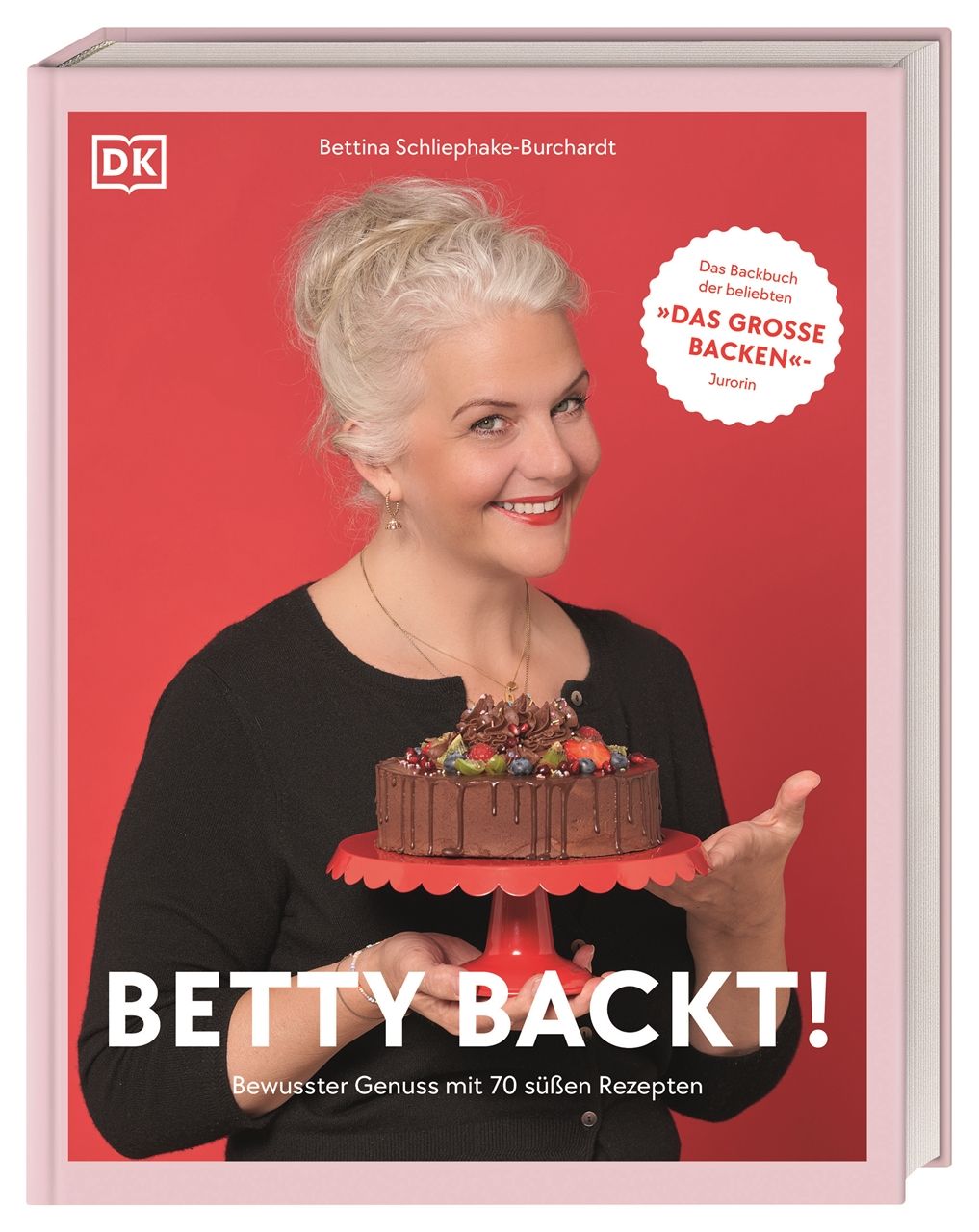 Buch "Betty backt!". Frau hält Kuchen auf rotem Ständer. Roter Hintergrund. Titel und Autor sichtbar.