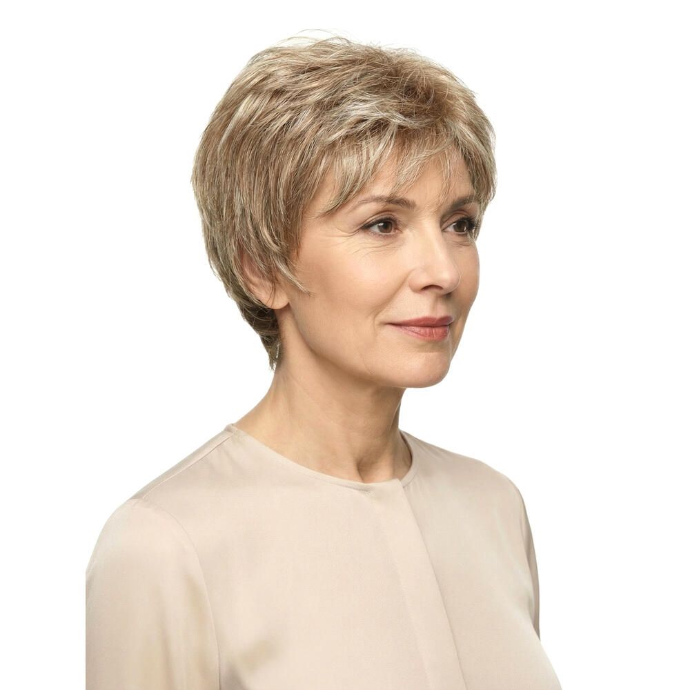 Kurzhaarperücke in Blondtönen. Dreiviertelansicht einer Frau mit Perücke. Helles Oberteil, weißer Hintergrund.