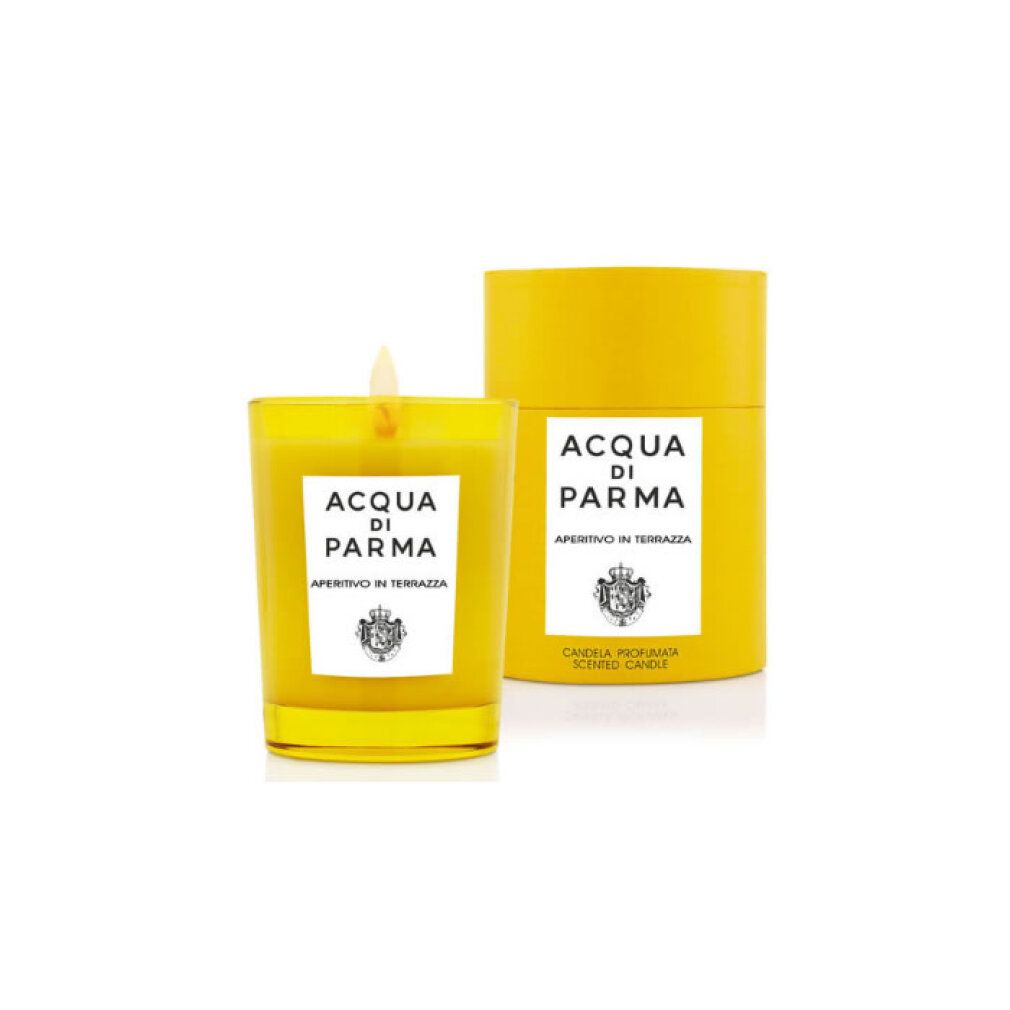 Gelbe Kerze in Glasbehälter mit Flamme. Daneben die passende Verpackung. Beide tragen das Logo "Acqua di Parma".
