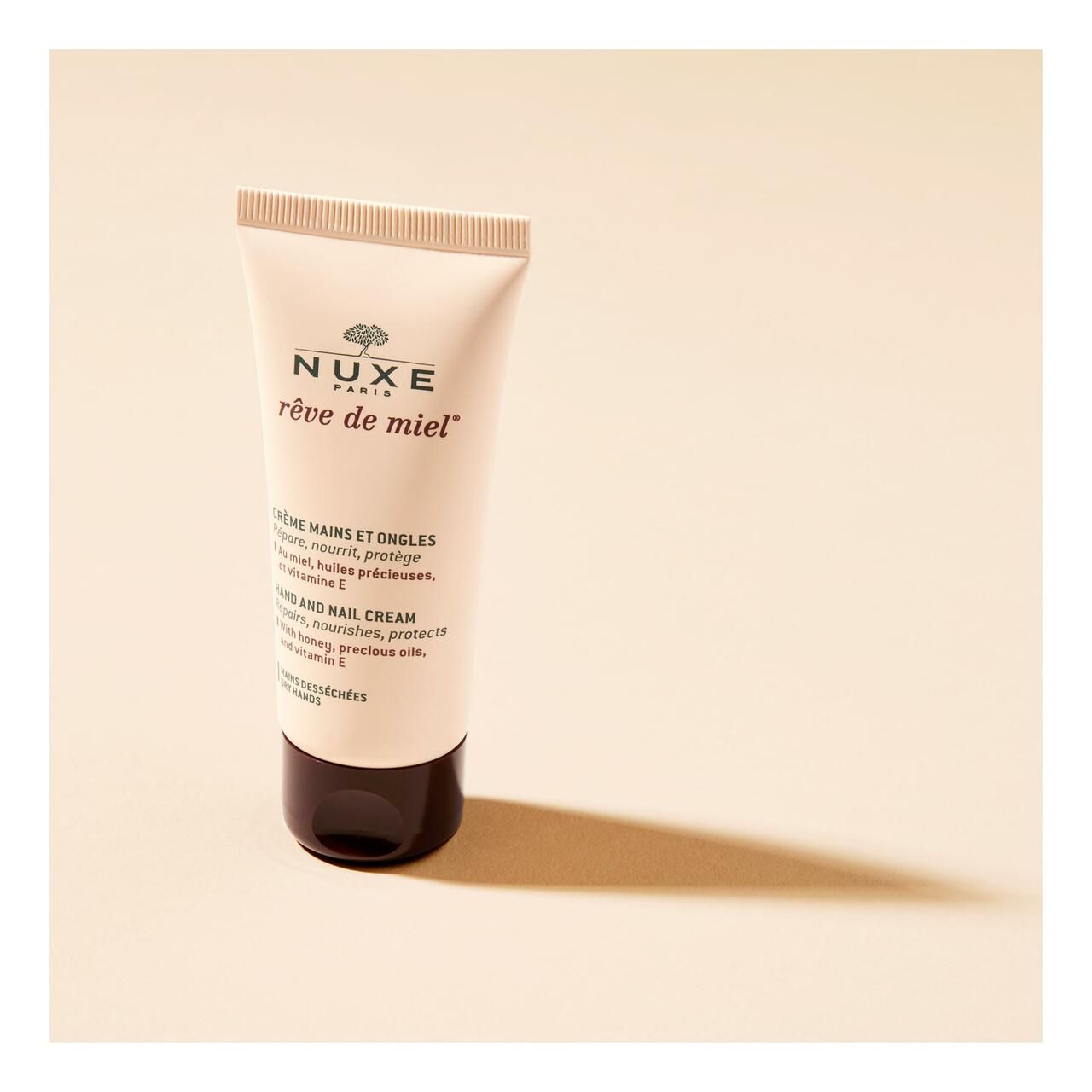 Creme-Tube. NUXE Rêve de Miel Hand- & Nagelcreme. Beige Tube mit braunem Deckel.