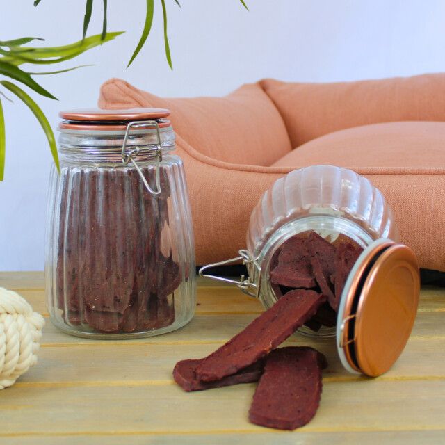 Lammfleischstreifen in Gläsern mit Deckel, auf Holzoberfläche.