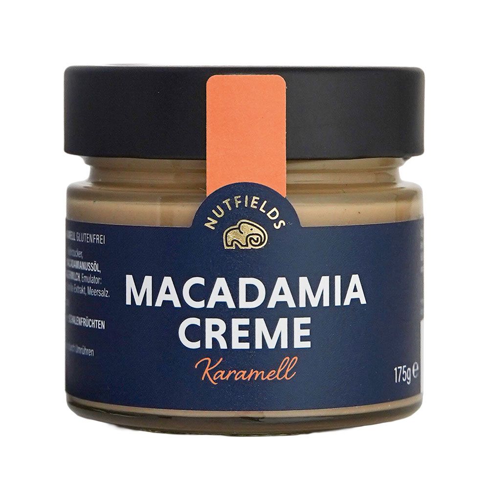 Glas mit Macadamia Creme, Karamell. Dunkelblauer Aufkleber mit Produktnamen und Logo. Orangefarbener Streifen. Schwarzer Deckel.