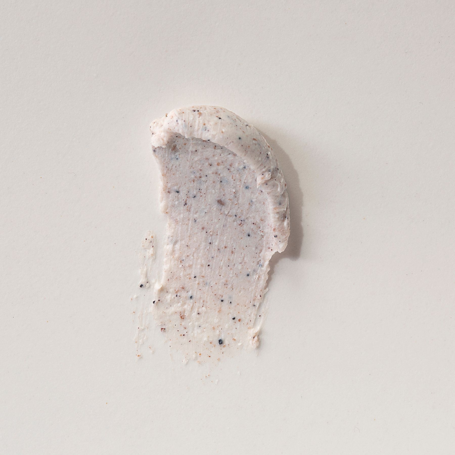 Eine Probe des Alkemy Karité Butter Scrub Körperpeelings auf hellem Hintergrund.