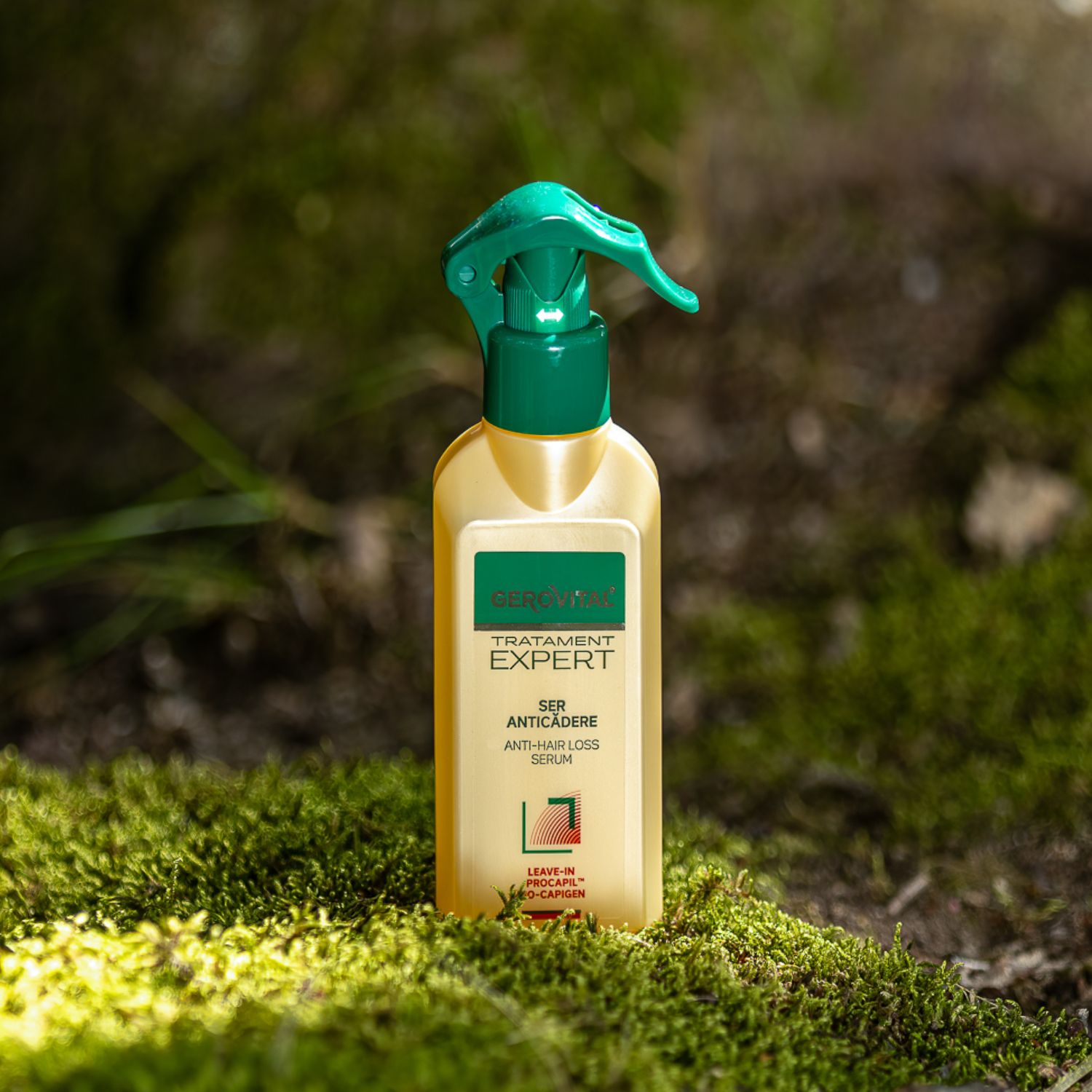 Beige Flasche mit grünem Sprühkopf. Aufschrift: Gerovital Tratament Expert, Ser Anticadere, Anti-Haarausfall Serum. Auf Moos platziert.