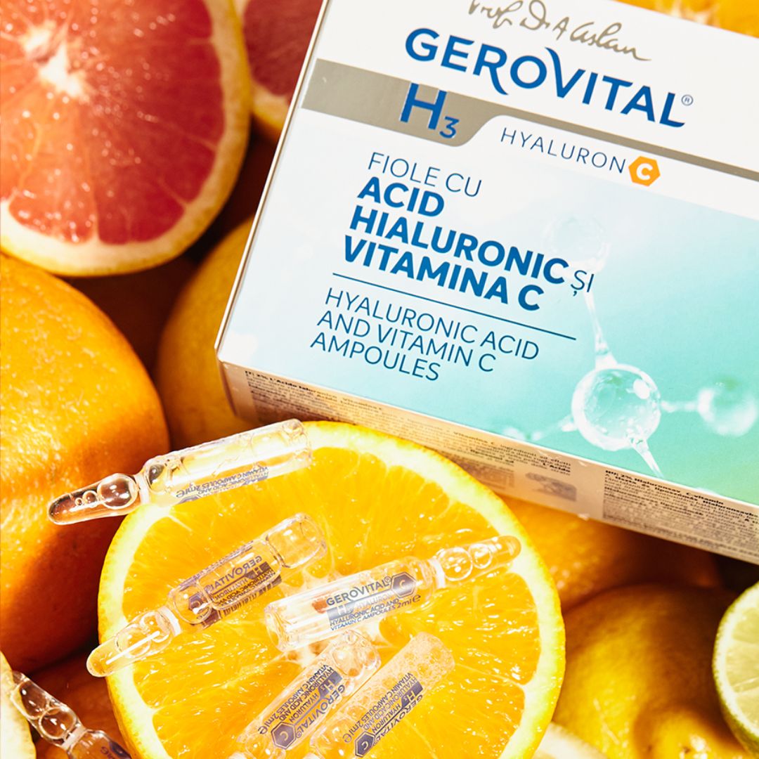 Gerovital-Ampullen mit Hyaluronsäure 2 % und Vitamin C auf Orangen und Grapefruit platziert.