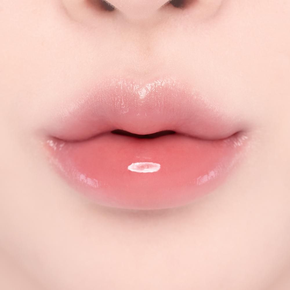 Nahaufnahme von vollen, rosafarbenen Lippen mit glänzendem Lipgloss und einem weißen Glanzpunkt.