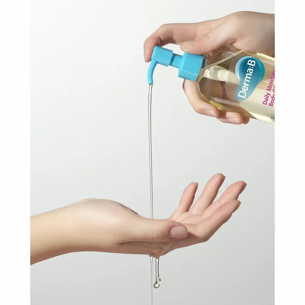Hände halten Körperölflasche. Öl wird in die Hand gegossen. Aufschrift: Derma:B, Daily Moisture Body Oil.