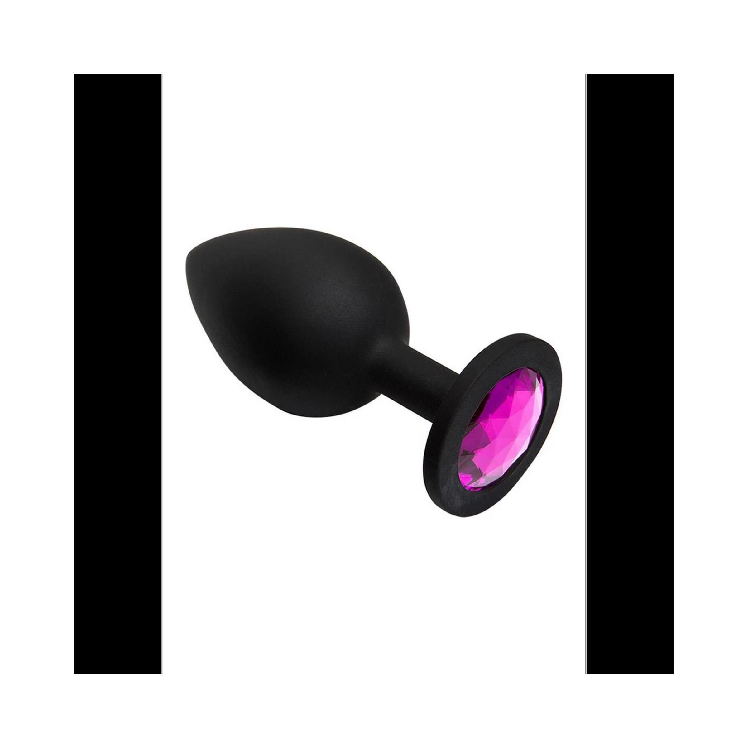 Schwarzer Plug mit pinkfarbenem Juwel. Kegelförmiger Kopf, runder Sockel. Aus Silikon.