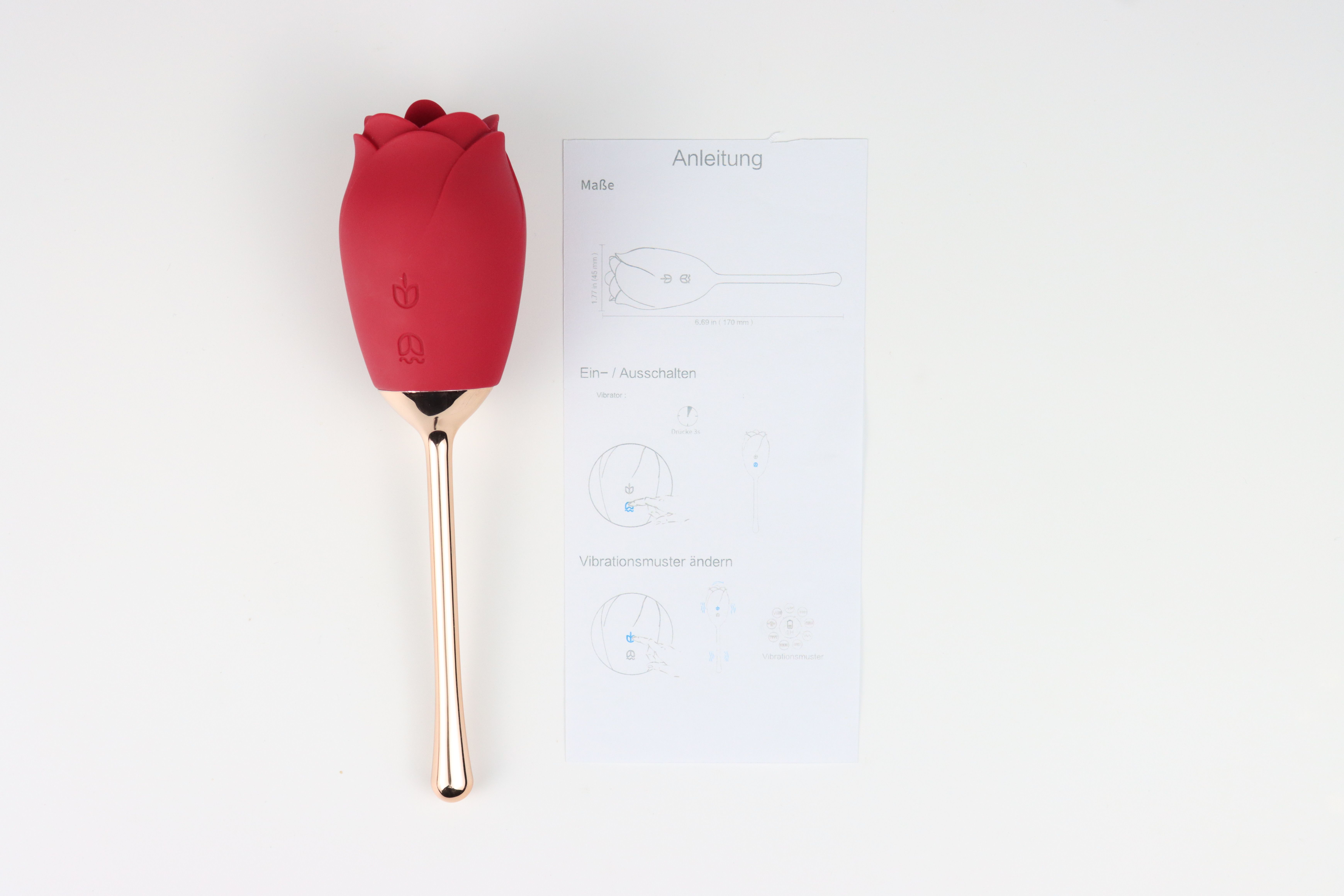 Roter Vibrator in Rosenform mit Stiel und Bedienungsanleitung. Text auf Anleitung.